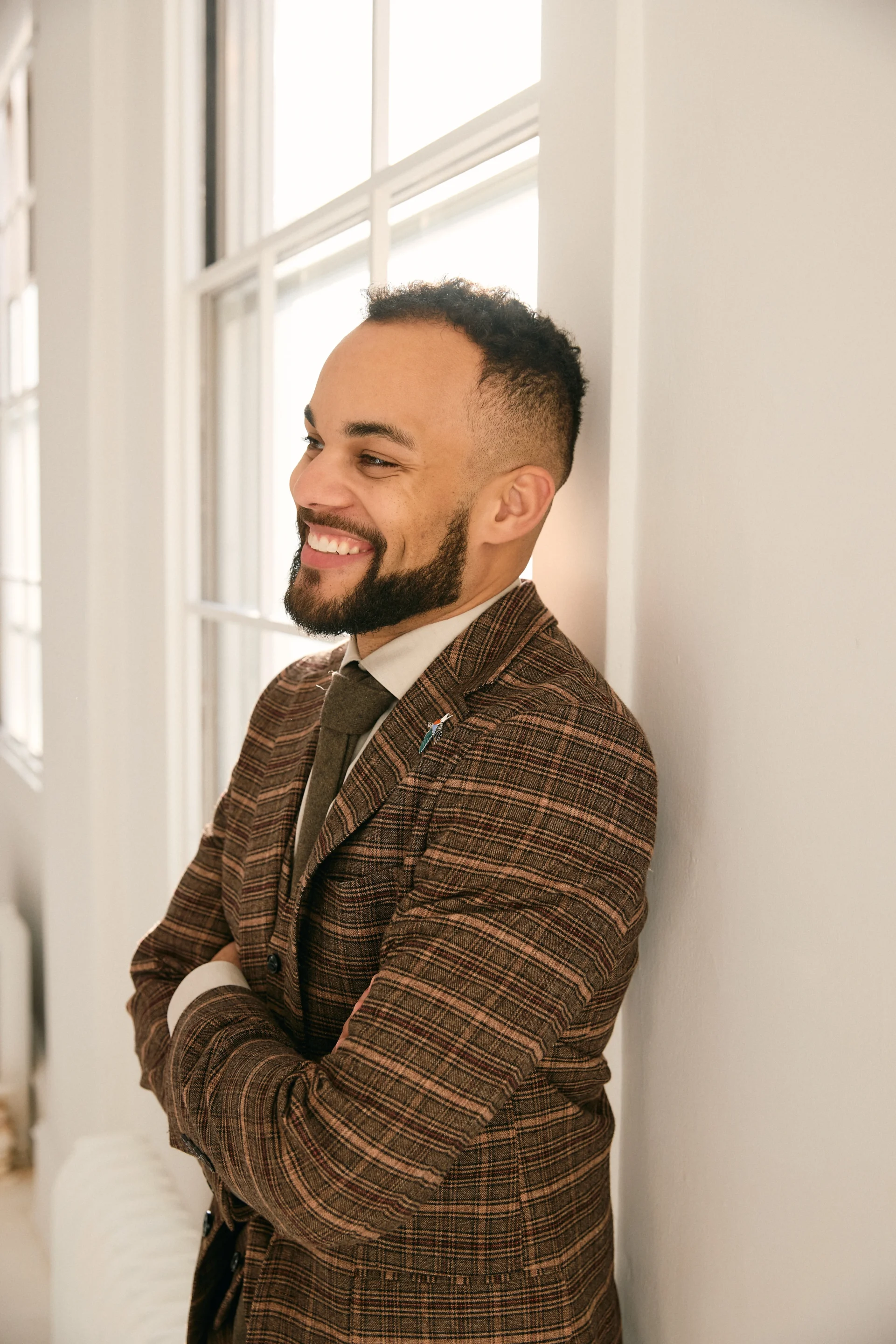 Tre Bynoe Financial Planner Tre Bynoe leaning against window